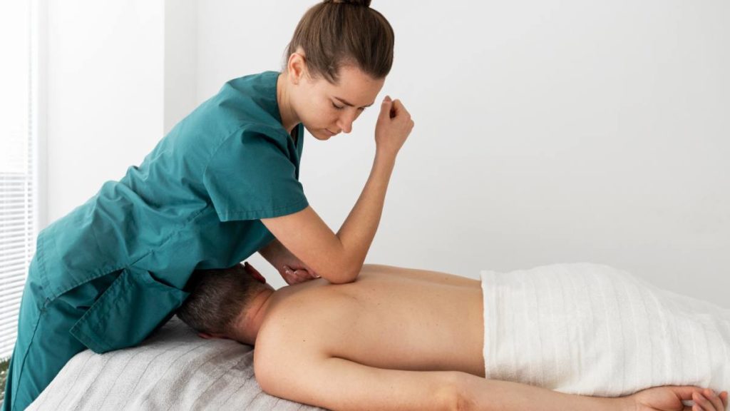 Fisioterapeuta a realizar uma massagem terapêutica nas costas de um paciente